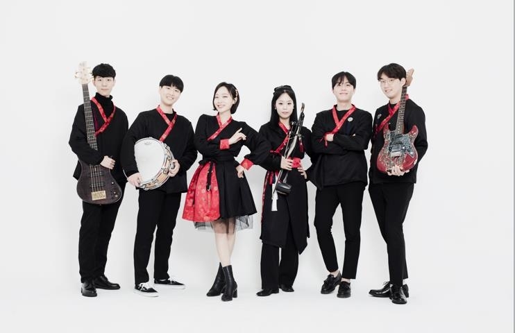 This is a picture of six people in a wedding band in hanbok holding an instrument.